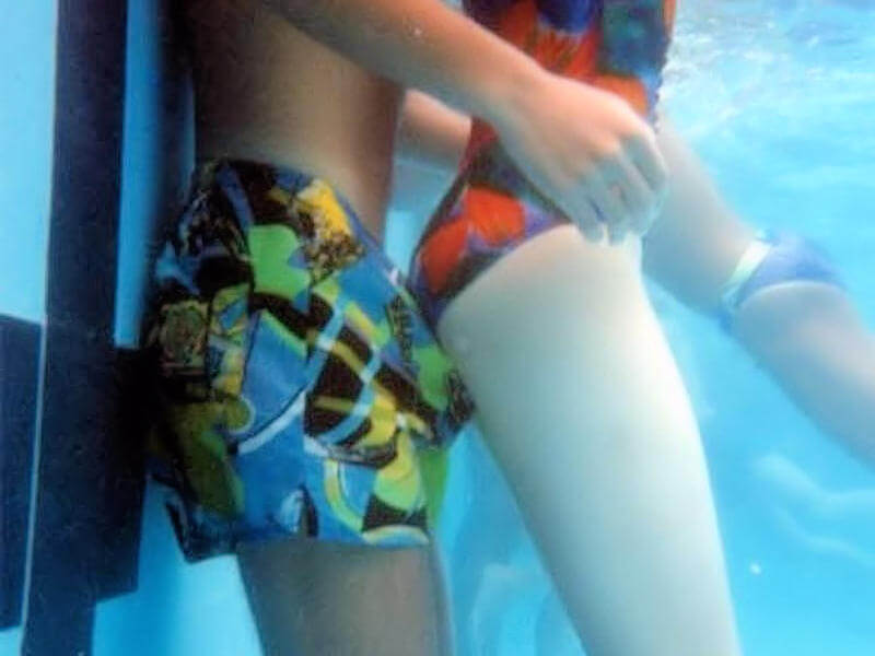 プールの水中でイチャつくカップルのエロ画像